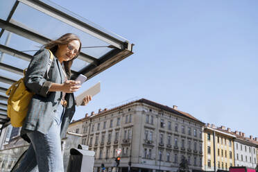 Frau mit Smartphone und Spaziergang unter dem Himmel in der Stadt - NDEF00992