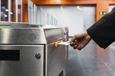 Young woman's hand taking ticket from machine at subway station - PNAF05967