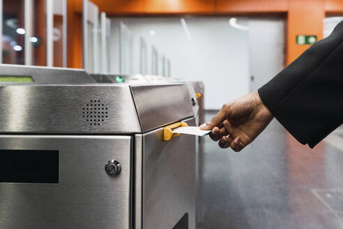 Young woman's hand taking ticket from machine at subway station - PNAF05967