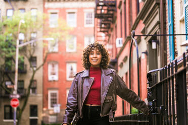 Glückliche afroamerikanische Frau, die lächelt, schöne junge Frau, die spazieren geht und Spaß hat in New York City - DMDF01537