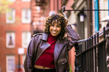 Glückliche afroamerikanische Frau, die lächelt, schöne junge Frau, die spazieren geht und Spaß hat in New York City - DMDF01538