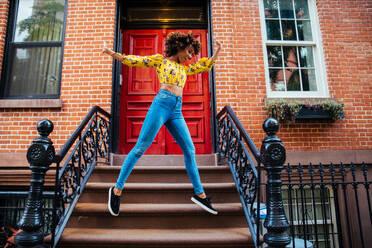 Glückliche afroamerikanische Frau, die lächelt, schöne junge Frau, die spazieren geht und Spaß hat in New York City - DMDF01546