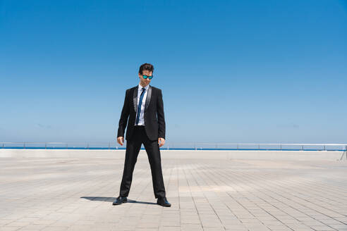 Happy and handsome adult businessman wearing elegant suit standing outdoors, full body portrait - DMDF01581