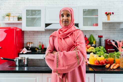 Glückliche mittelöstliche Frau trägt Abaya zu Hause - Schöne muslimische erwachsene Frau Porträt in der Wohnung, Konzepte über häusliches Leben und islamischen Lebensstil - DMDF01632