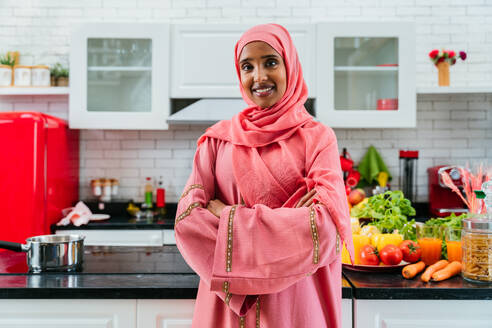 Glückliche mittelöstliche Frau trägt Abaya zu Hause - Schöne muslimische erwachsene Frau Porträt in der Wohnung, Konzepte über häusliches Leben und islamischen Lebensstil - DMDF01634