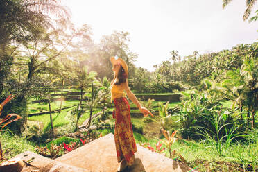 Young woman on green cascade rice field plantation at Tegalalang terrace. Bali, Indonesia - Beautiful female model posing at rice terrace in Ubud - DMDF01645