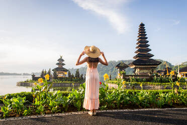 Junge Frau im Pura Ulun Danu Bratan, Bali. Hindu-Tempel umgeben von Blumen am Bratan-See, Bali. - DMDF01679