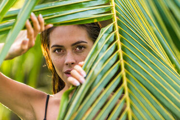 Beautiful woman in bikini relaxing in a outdoor swimming pool in a Bali luxury resort - Young pretty female model posing in a balinese villa - DMDF01731