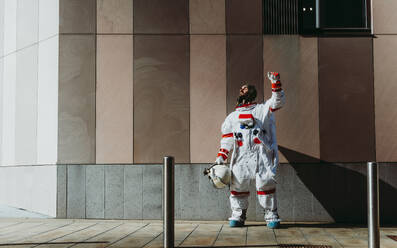 Spaceman in a futuristic station. astronaut with space suit walking in an urban area - DMDF01774