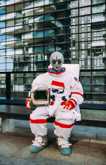 Alien-Raumfahrer in einer futuristischen Station. Astronaut mit Raumanzug geht in einem städtischen Gebiet spazieren - DMDF01778