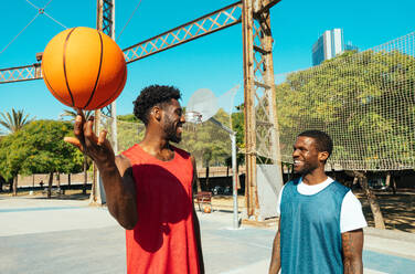 One vs one basketball game training at the court. Cinematic look image of friends practicing shots and slam dunks in an urban area - DMDF01783