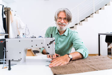 Clothing stylist creating a new design for a dress - Fashion designer working on a clothing brand in a textile factory - DMDF01807