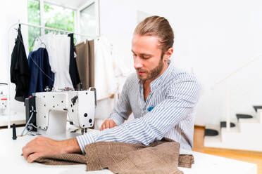 Bekleidungsstylist, der einen neuen Entwurf für ein Kleid entwirft - Modedesigner, der in einer Textilfabrik an einer Bekleidungsmarke arbeitet - DMDF01809
