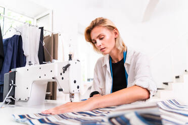 Modedesignerin bei der Arbeit in einem Bekleidungs-Start-up-Atelier - Bekleidungsschneiderin bei der Arbeit an einer neuen Kollektion - DMDF01814