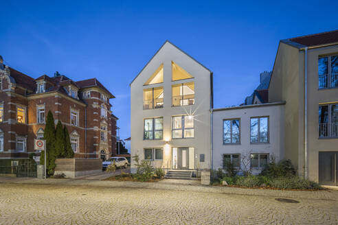 Germany, Lower Saxony, Wolfenbuttel, Facade of white-painted modern house at dusk  - PVCF01352