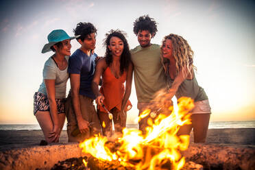 Multicultural group of friends partying on the beach - Young people celebrating during summer vacation, summertime and holidays concepts - DMDF01972