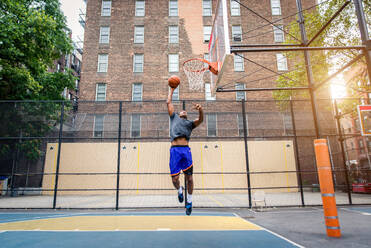 Afro-amerikanischer Basketballspieler beim Training auf einem Platz in New York - Sportlicher Mann beim Basketballspielen im Freien - DMDF01978