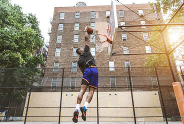 Afro-amerikanischer Basketballspieler beim Training auf einem Platz in New York - Sportlicher Mann beim Basketballspielen im Freien - DMDF01979