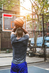 Afro-amerikanischer Basketballspieler beim Training auf einem Platz in New York - Sportlicher Mann beim Basketballspielen im Freien - DMDF01989