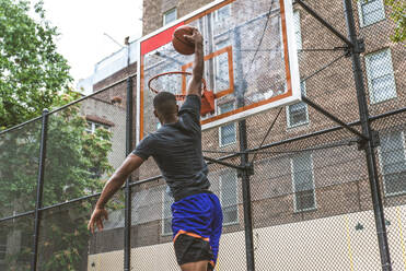 Afro-amerikanischer Basketballspieler beim Training auf einem Platz in New York - Sportlicher Mann beim Basketballspielen im Freien - DMDF01991