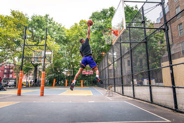 Afro-amerikanischer Basketballspieler beim Training auf einem Platz in New York - Sportlicher Mann beim Basketballspielen im Freien - DMDF01992