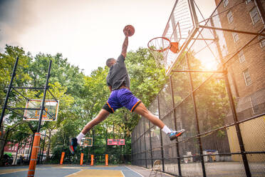 Afro-amerikanischer Basketballspieler beim Training auf einem Platz in New York - Sportlicher Mann beim Basketballspielen im Freien - DMDF01993