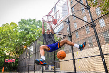 Afro-amerikanischer Basketballspieler beim Training auf einem Platz in New York - Sportlicher Mann beim Basketballspielen im Freien - DMDF01998