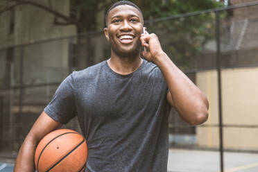 Afro-american basketball player training on a court in New York - Sportive man playing basket outdoors - DMDF01999