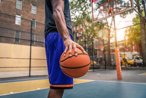 Afro-amerikanischer Basketballspieler beim Training auf einem Platz in New York - Sportlicher Mann beim Basketballspielen im Freien - DMDF02001