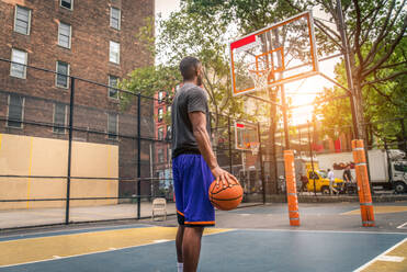 Afro-amerikanischer Basketballspieler beim Training auf einem Platz in New York - Sportlicher Mann beim Basketballspielen im Freien - DMDF02002