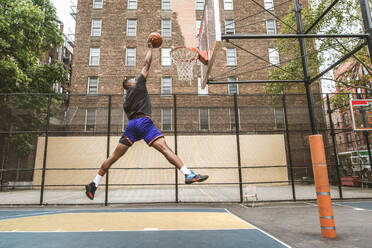 Afro-amerikanischer Basketballspieler beim Training auf einem Platz in New York - Sportlicher Mann beim Basketballspielen im Freien - DMDF02005