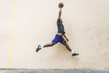 Afro-american basketball player training on a court in New York - Sportive man playing basket outdoors - DMDF02006