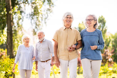Gruppe glücklicher älterer Menschen, die sich im Freien im Park treffen - Alte Menschen im Alter von 60, 70, 80 Jahren, die Spaß haben und Zeit miteinander verbringen, Konzepte über ältere Menschen, Seniorität und Wellness im Alter - DMDF02127