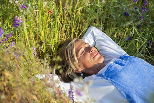 Woman with eyes closed relaxing in meadow - BFRF02434