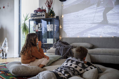 Bruder und Schwester schauen gemeinsam einen Film im Wohnzimmer - IKF01110