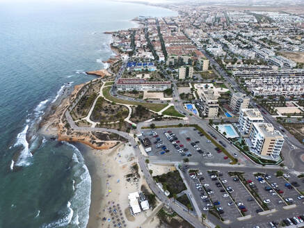 Spanien, Valencianische Gemeinschaft, Mil Palmeras, Luftaufnahme der Küstenstadt mit Parkplatz am Strand im Vordergrund - DMHF00096