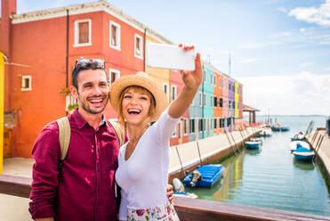 Beatiful young couple having fun while visiting Venice - Tourists travelling in Italy and sightseeing the most relevant landmarks of Venezia - Concepts about lifestyle, travel, tourism - DMDF02180
