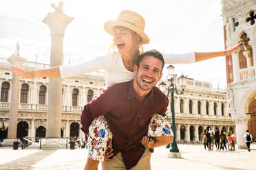 Schönes junges Paar, das sich bei einem Besuch in Venedig amüsiert - Touristen, die in Italien reisen und die wichtigsten Sehenswürdigkeiten von Venedig besichtigen - Konzepte für Lebensstil, Reisen, Tourismus - DMDF02189