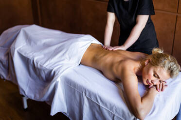 Beautiful woman relaxing in a beauty spa hotel - Client having a beauty treatment in a beauty spa salon - DMDF02281