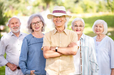 Gruppe glücklicher älterer Menschen, die sich im Freien im Park treffen - Alte Menschen im Alter von 60, 70, 80 Jahren, die Spaß haben und Zeit miteinander verbringen, Konzepte über ältere Menschen, Seniorität und Wellness im Alter - DMDF02303