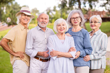 Gruppe glücklicher älterer Menschen, die sich im Freien im Park treffen - Alte Menschen im Alter von 60, 70, 80 Jahren, die Spaß haben und Zeit miteinander verbringen, Konzepte über ältere Menschen, Seniorität und Wellness im Alter - DMDF02306