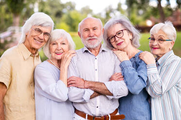 Gruppe glücklicher älterer Menschen, die sich im Freien im Park treffen - Alte Menschen im Alter von 60, 70, 80 Jahren, die Spaß haben und Zeit miteinander verbringen, Konzepte über ältere Menschen, Seniorität und Wellness im Alter - DMDF02307