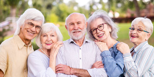 Gruppe glücklicher älterer Menschen, die sich im Freien im Park treffen - Alte Menschen im Alter von 60, 70, 80 Jahren, die Spaß haben und Zeit miteinander verbringen, Konzepte über ältere Menschen, Seniorität und Wellness im Alter - DMDF02308