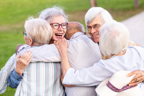 Gruppe glücklicher älterer Menschen, die sich im Freien im Park treffen - Alte Menschen im Alter von 60, 70, 80 Jahren, die Spaß haben und Zeit miteinander verbringen, Konzepte über ältere Menschen, Seniorität und Wellness im Alter - DMDF02311