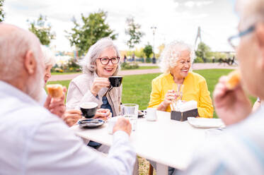 Gruppe glücklicher älterer Menschen, die sich im Freien in der Bar-Cafeteria treffen - Alte Menschen im Alter von 60, 70, 80 Jahren, die Spaß haben und Zeit miteinander verbringen, Konzepte über ältere Menschen, Seniorität und Wellness-Aging - DMDF02351