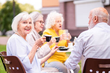 Gruppe glücklicher älterer Menschen, die sich im Freien in der Bar-Cafeteria treffen - Alte Menschen im Alter von 60, 70, 80 Jahren, die Spaß haben und Zeit miteinander verbringen, Konzepte über ältere Menschen, Seniorität und Wellness-Aging - DMDF02355