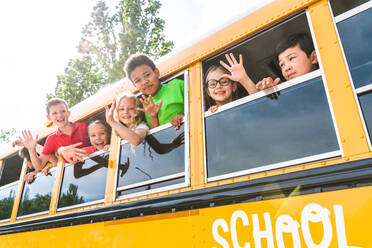 Group of young students attending primary school on a yellow school bus - Elementary school kids ha1ving fun - DMDF02358