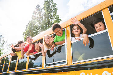 Group of young students attending primary school on a yellow school bus - Elementary school kids ha1ving fun - DMDF02359