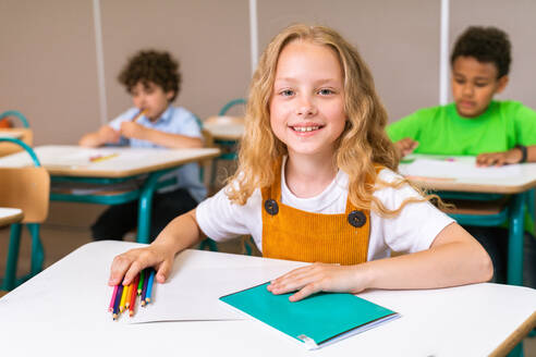 Gemischtrassige Gruppe von Kindern in der Grundschule - Verspielte Schüler genießen die Schulzeit und den Unterricht mit Lehrern und Mitschülern - DMDF02377