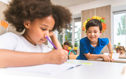 Gemischtrassige Gruppe von Kindern in der Grundschule - Verspielte Schüler genießen die Schulzeit und den Unterricht mit Lehrern und Mitschülern - DMDF02379